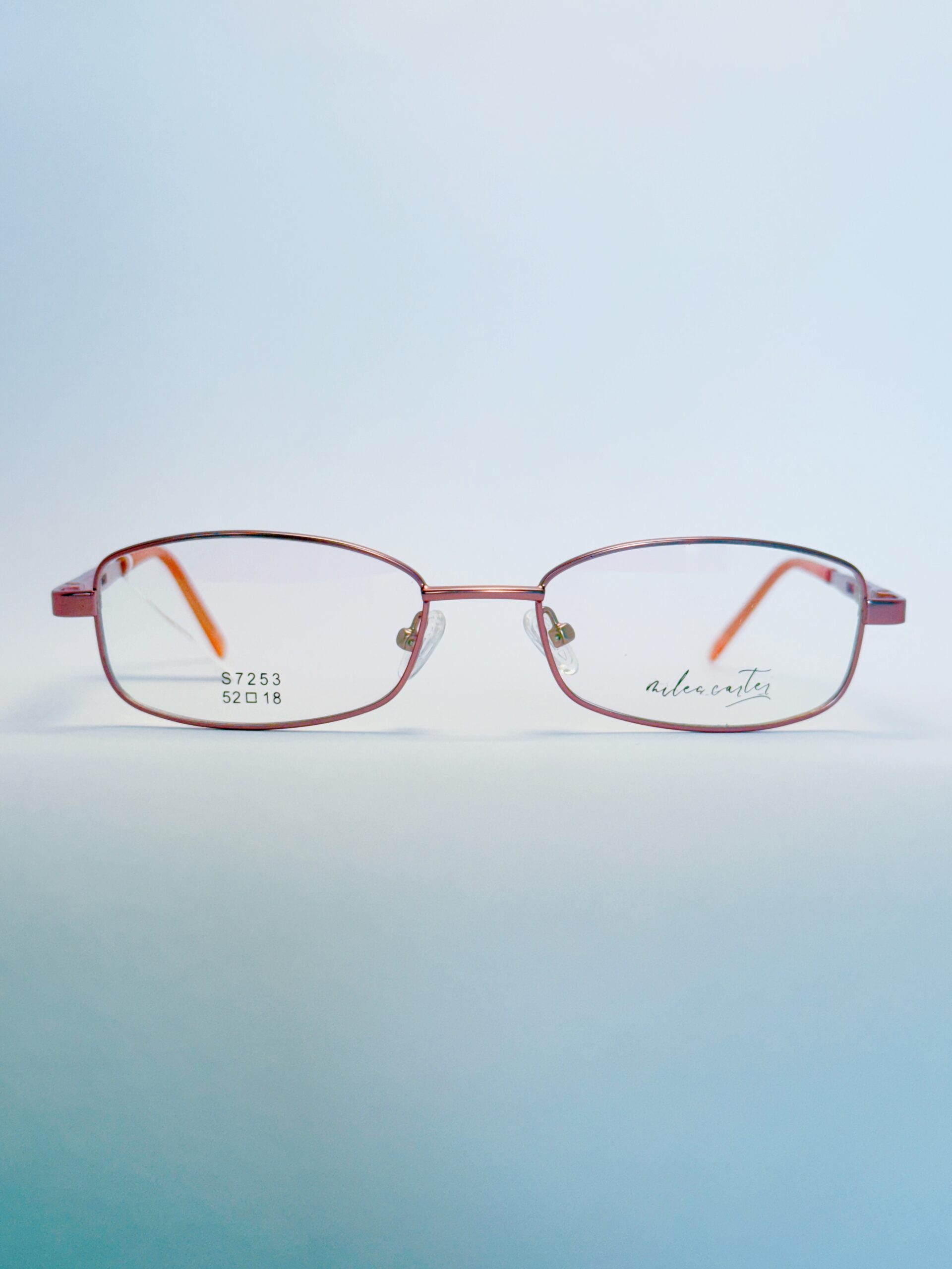 Stylish pink metal rectangular eyeglasses with orange temple tips, ideal for fashion and vision enhancement." . Available at website - www.spexovision.com
